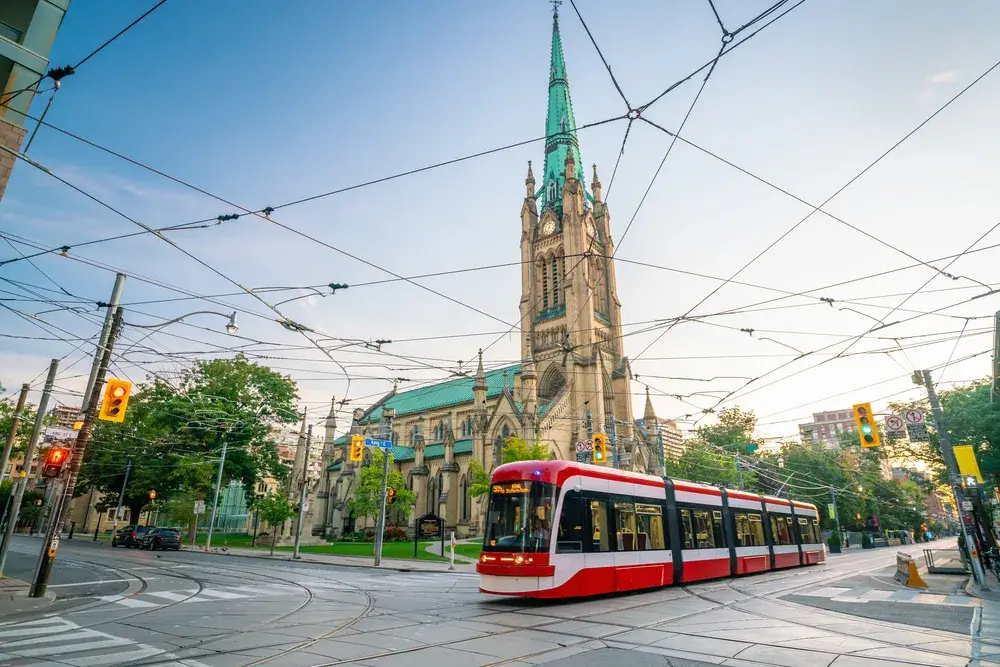 Downtown skyline in Toronto pictured during the best time to visit with a church in the background