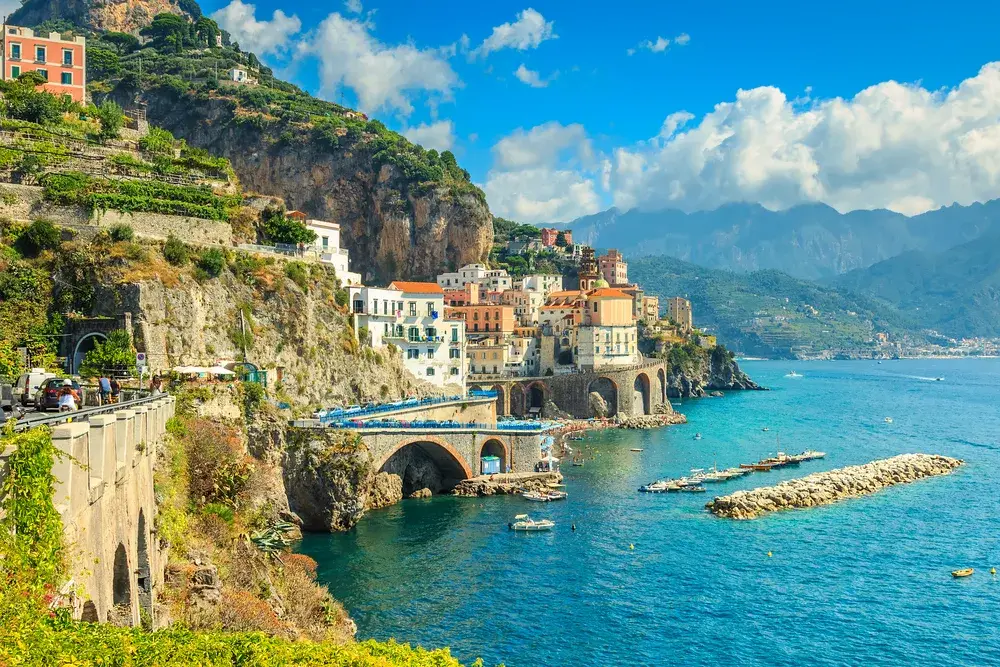 Gorgeous view of Positano pictured from a cliff looking out toward the rocky jetty