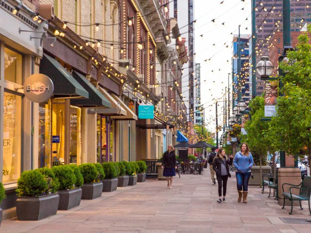 Two ladies walking along a semi-empty street in Larimer Square next to little shops