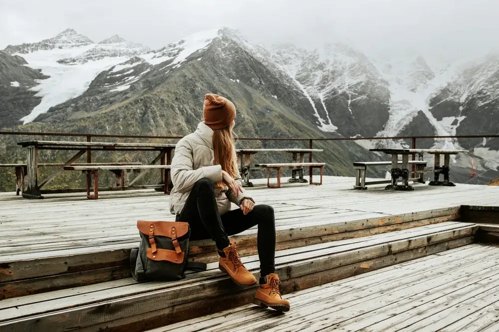 Woman in black yoga pants pictured looking over her shoulder in Balkaria toward the mountains