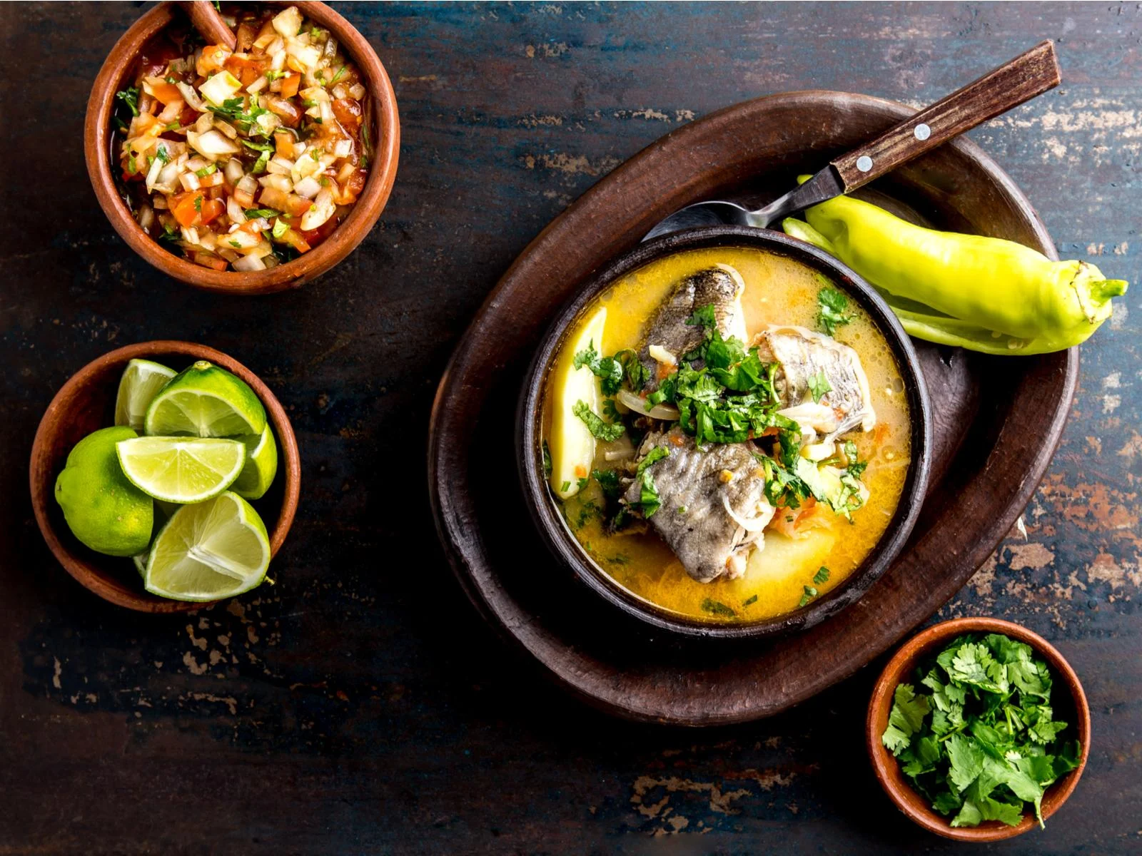 Caldillo de Congrio served in a clay bowl pictured in a layflat image