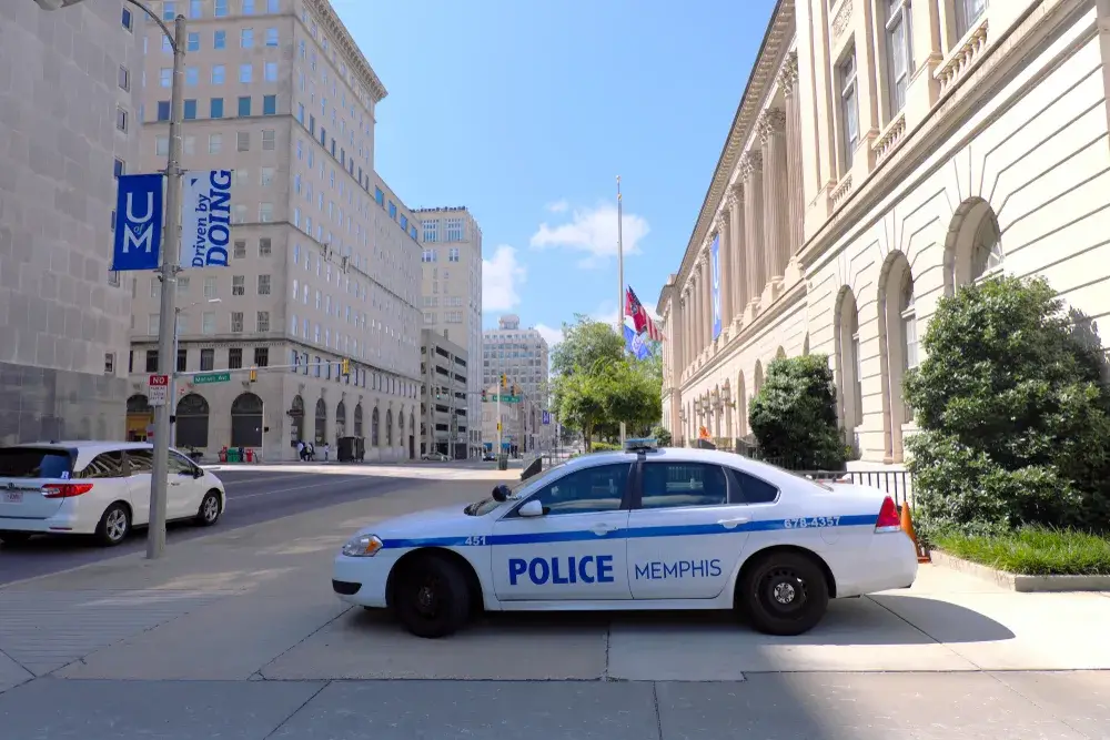 Downtown, one of the areas to avoid in Memphis, pictured with a police car outside of the tall buildings