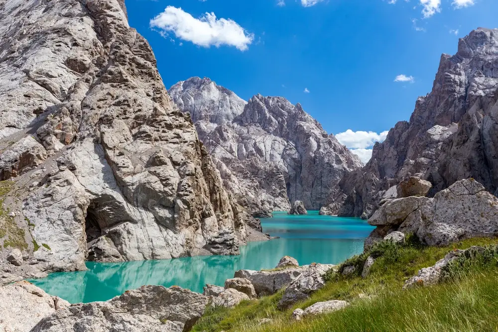 Amazing view with mountains towering over either side of the teal water of Lake Kelsuu pictured during the least busy time to visit Kyrgyzstan