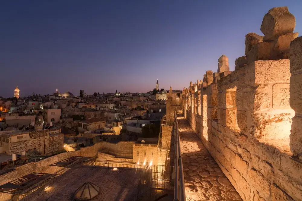 Night view of the Old City in Jerusalem as seen from the top of a wall with the stones lit up