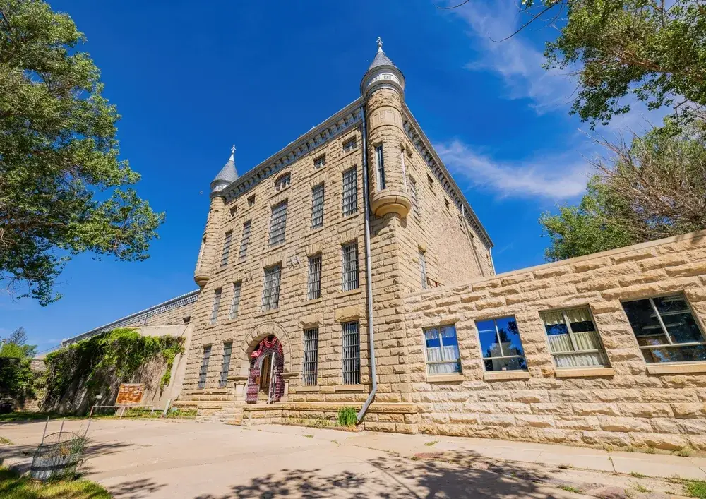 Castle-like exterior of the Frontier Prison Museum with its menacing exterior towering over the reader