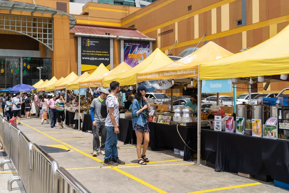 Two Malaysian people buying goods from the open-air market in Petaling Jaya