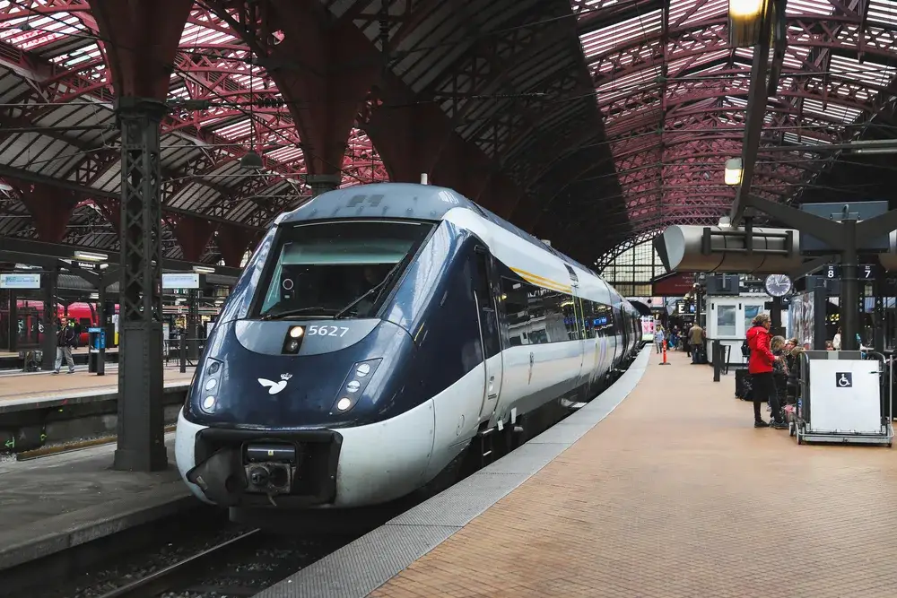 Train in Copenhagen pictured leaving the station in the spring, one of the cheapest times to visit Denmark