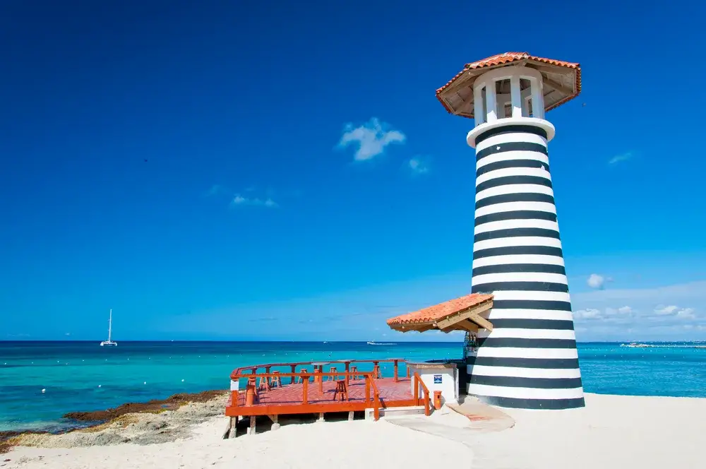 Black and white lighthouse on a clear day overlooking the ocean