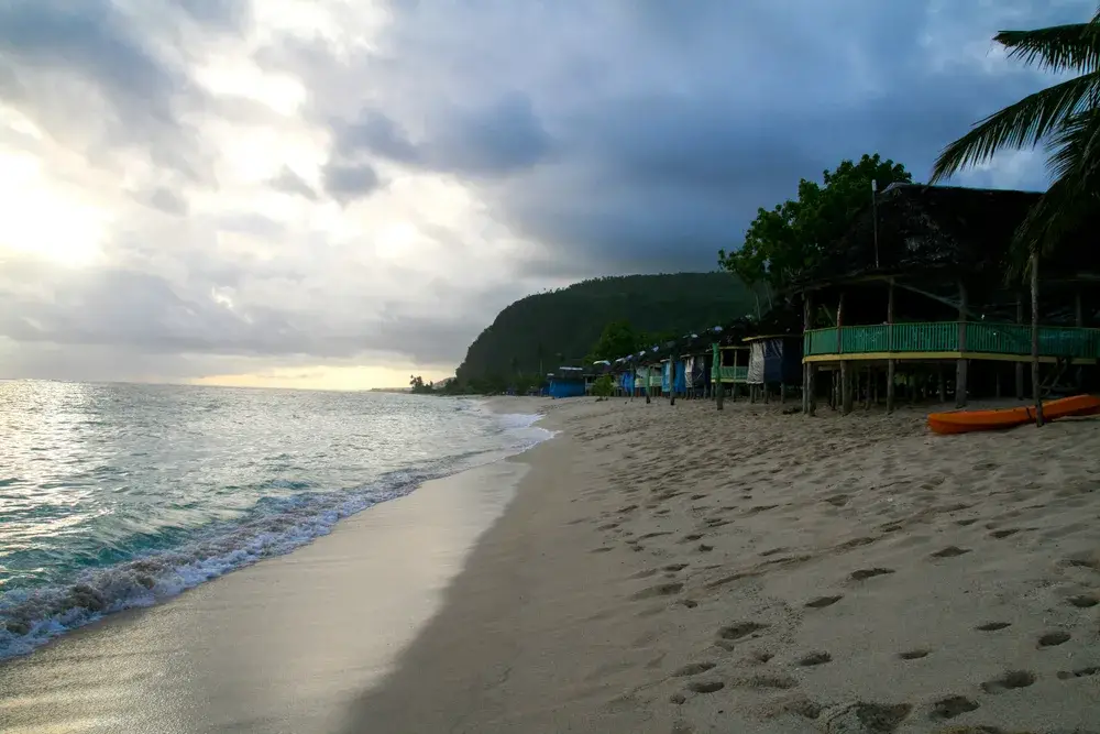 Rain clouds overhead, as seen from the perspective of a person walking down the Lalomanu Beach during the worst time to visit Samoa