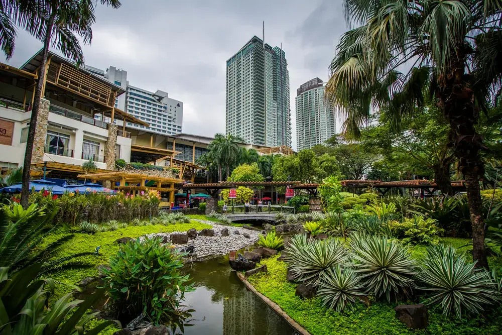 Neat skyscraper as seen from the gorgeous gardens in Greenbelt Park, pictured during the best time to visit the Philippines