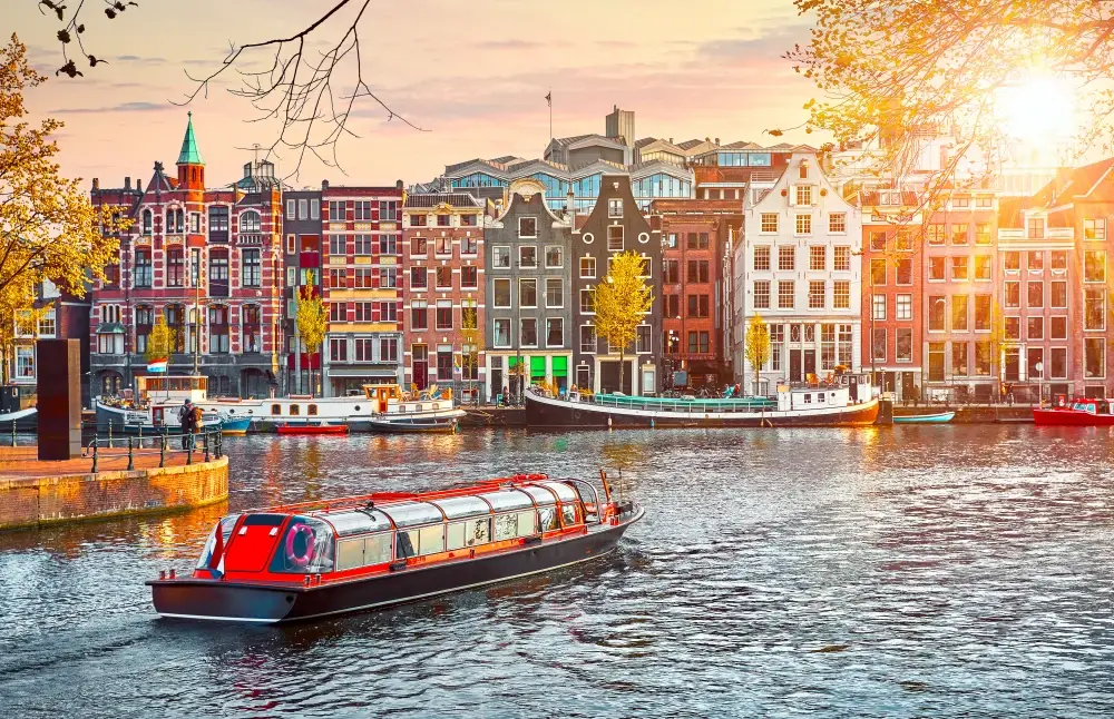 Amstel landmark with boat in the channel at sunrise to answer the question is Amsterdam safe