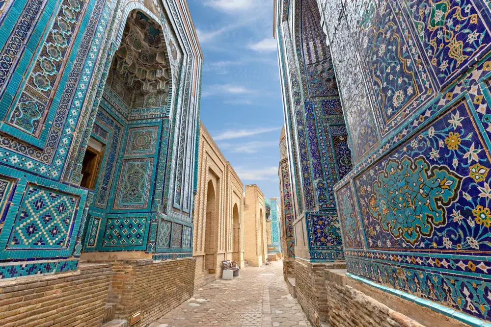 Historical necropolis of Skakhi Zinda in Samarkand pictured with blue walls lining the stone street during the least busy time to visit Uzbekistan