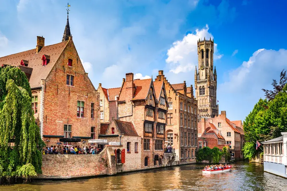 Burges pictured from the water in between the old brick buildings for a piece on the best time to visit Belgium