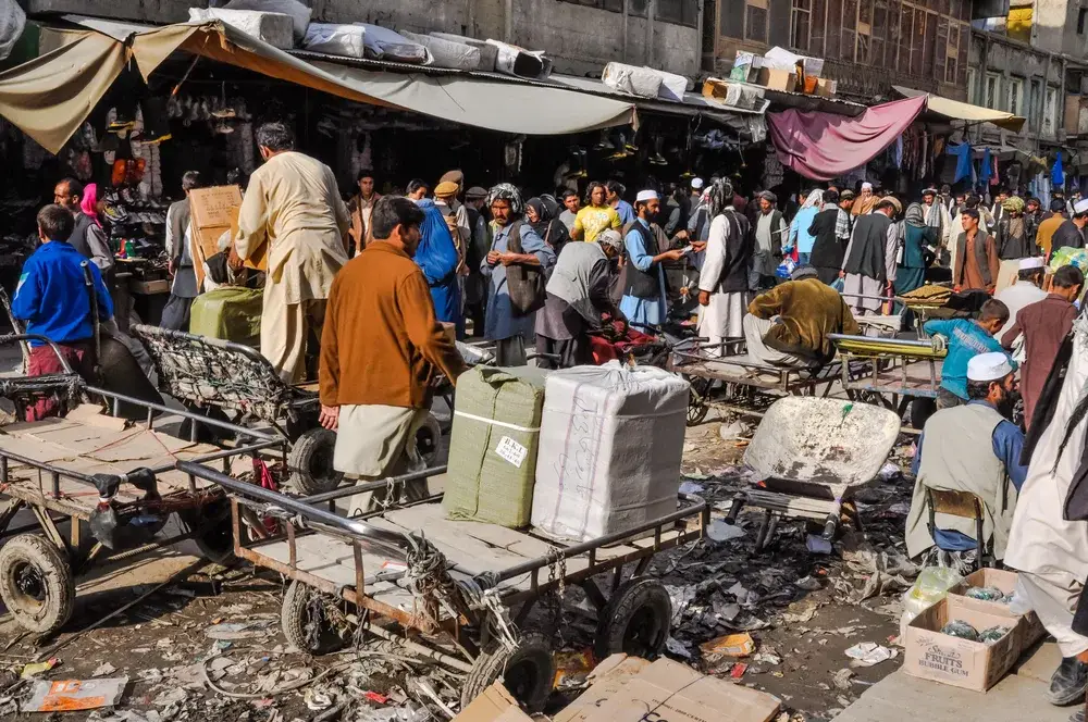 For a guide to whether or not Kabul is safe to visit, a bunch of people gather in a shopping market