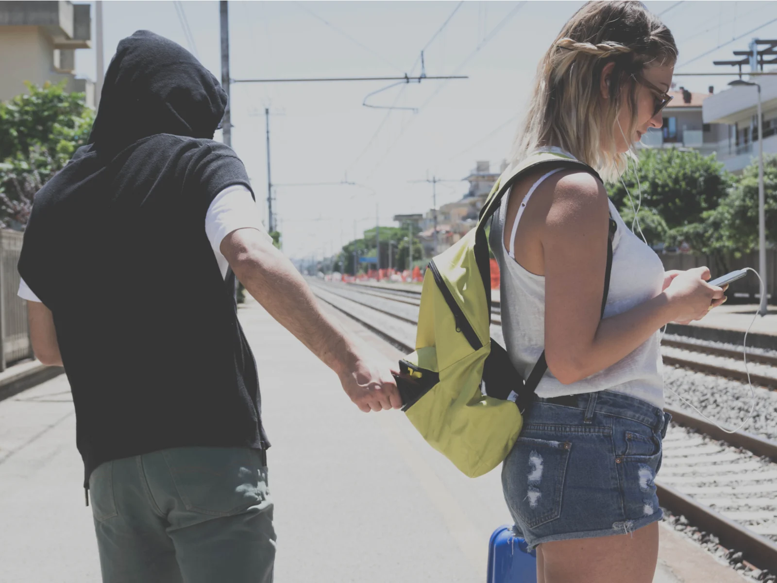 Woman at a train station getting her wallet stolen by a pickpocket