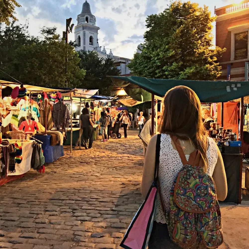 Woman walking through an open-air market for a piece titled Is Argentina Safe to Visit