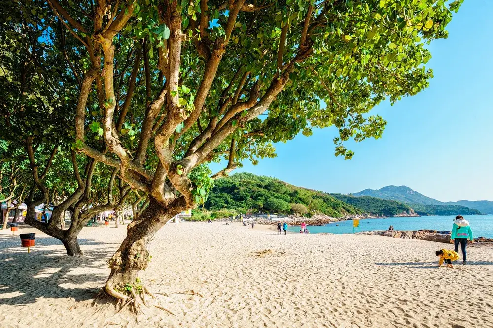 White sand beach pictured looking out toward the blue water during the best time to visit Hong Kong