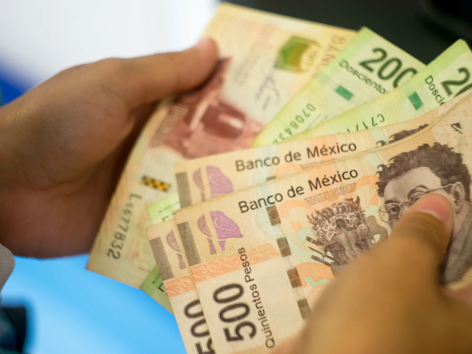 Person pulling money from an ATM for a piece titled Is Mexico Safe