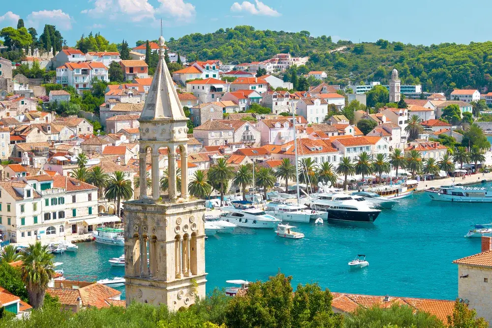 Amazing view of the Hvar harbor as seen from the air with still teal water in the bay on which expensive boats float