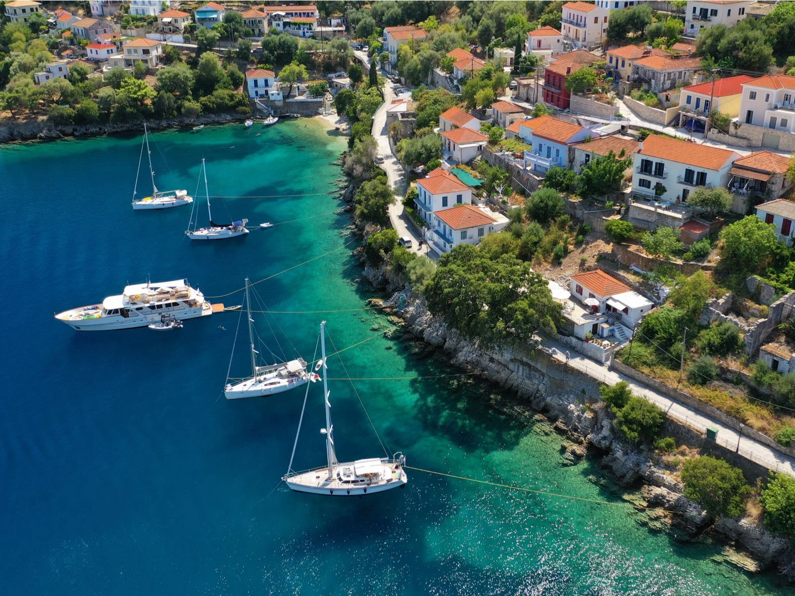 Five boats anchored near the beautiful Kioni Village at Ithaca island, a piece on the best islands in Greece to visit