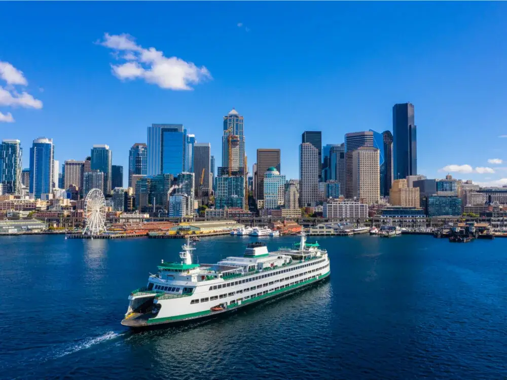 Ferry crossing the water going toward downtown during the best time to visit Seattle