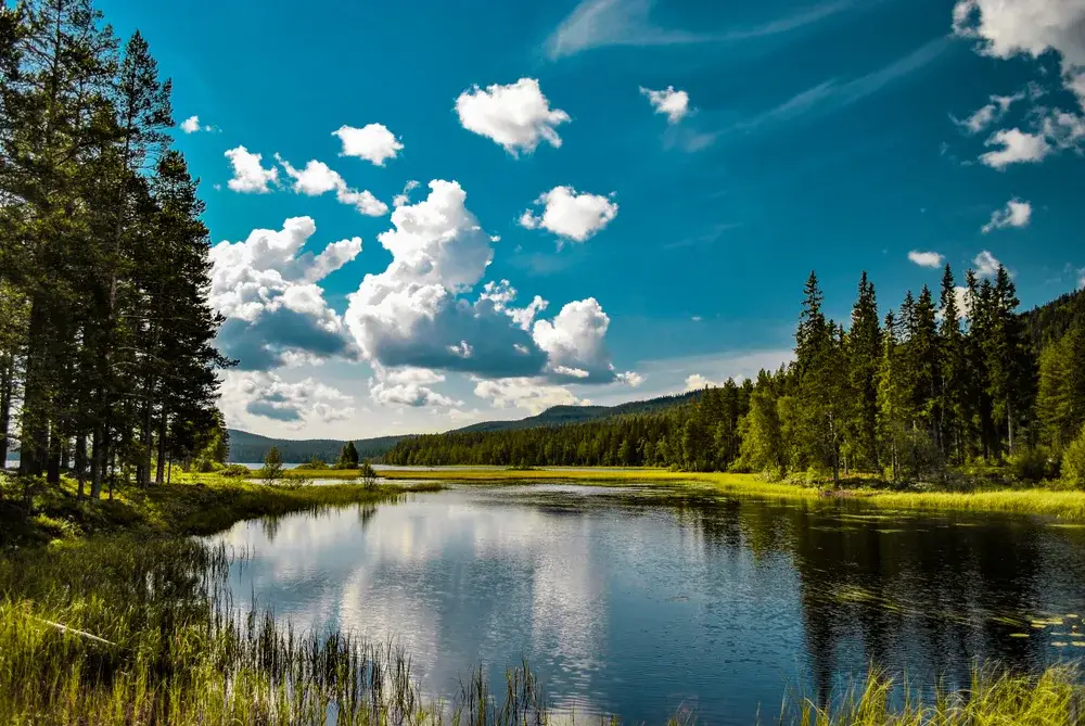 View of lake in Mora with a blue sky with scattered clouds during the best time to visit Sweden