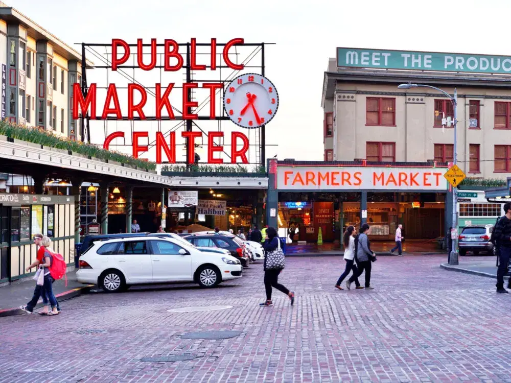 Pike Place Market on a not-busy day during the least busy time to visit Seattle with various neon signs in the background