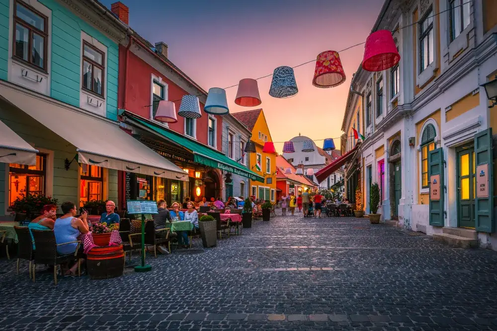 People dining outside on a street in Szentendre, a safe place to visit in Hungary for a piece on Is Hungary Safe