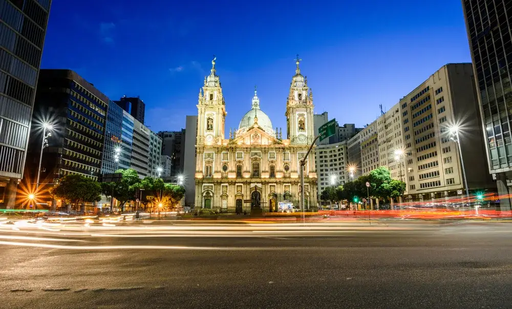 Downtown view at dusk of the Candelaria Church in a low-exposure image with cars driving by on either side of the street