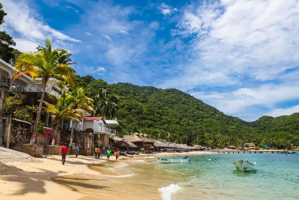 Tourists walking along a gorgeous beach in Idyllic Puerta Vallarta