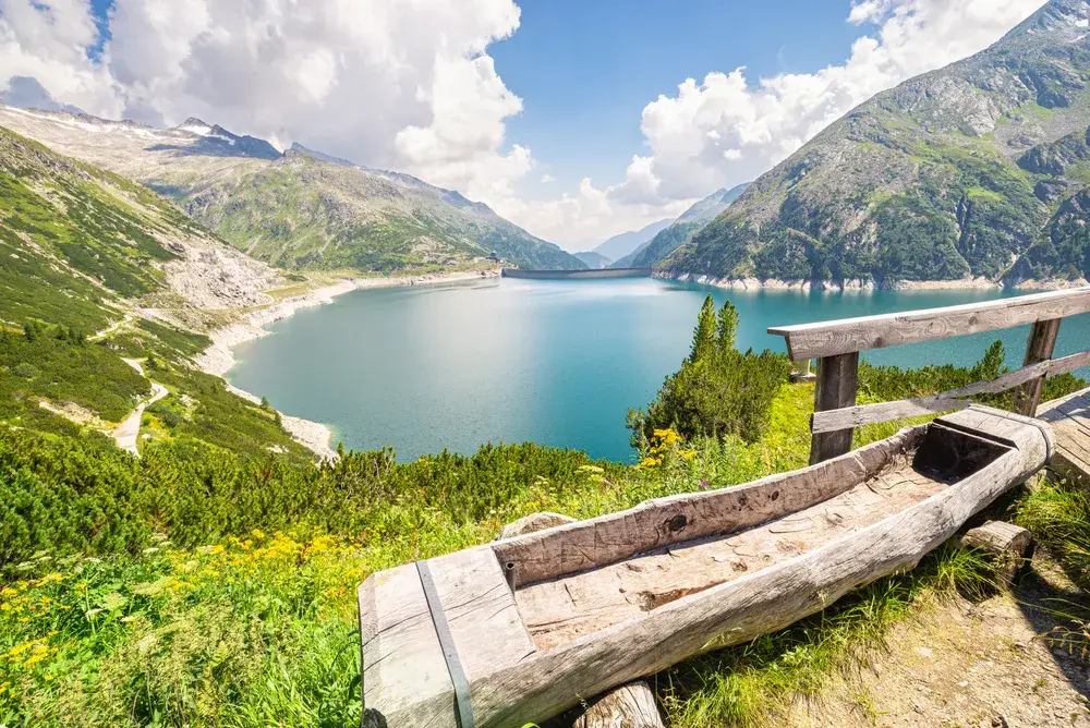 Old log carved into a bench overlooking the scenic view of the walking paths and lake in one of the best places to see in Austria, Carinthia