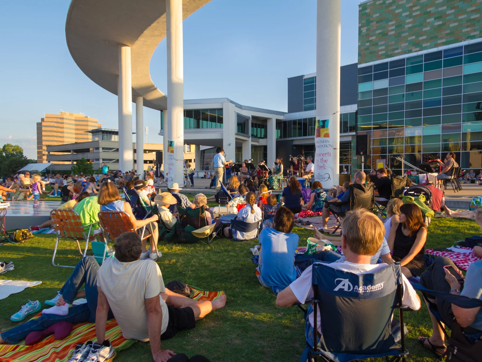 People sitting on a lawn watching live music in a park during the best time to visit Austin